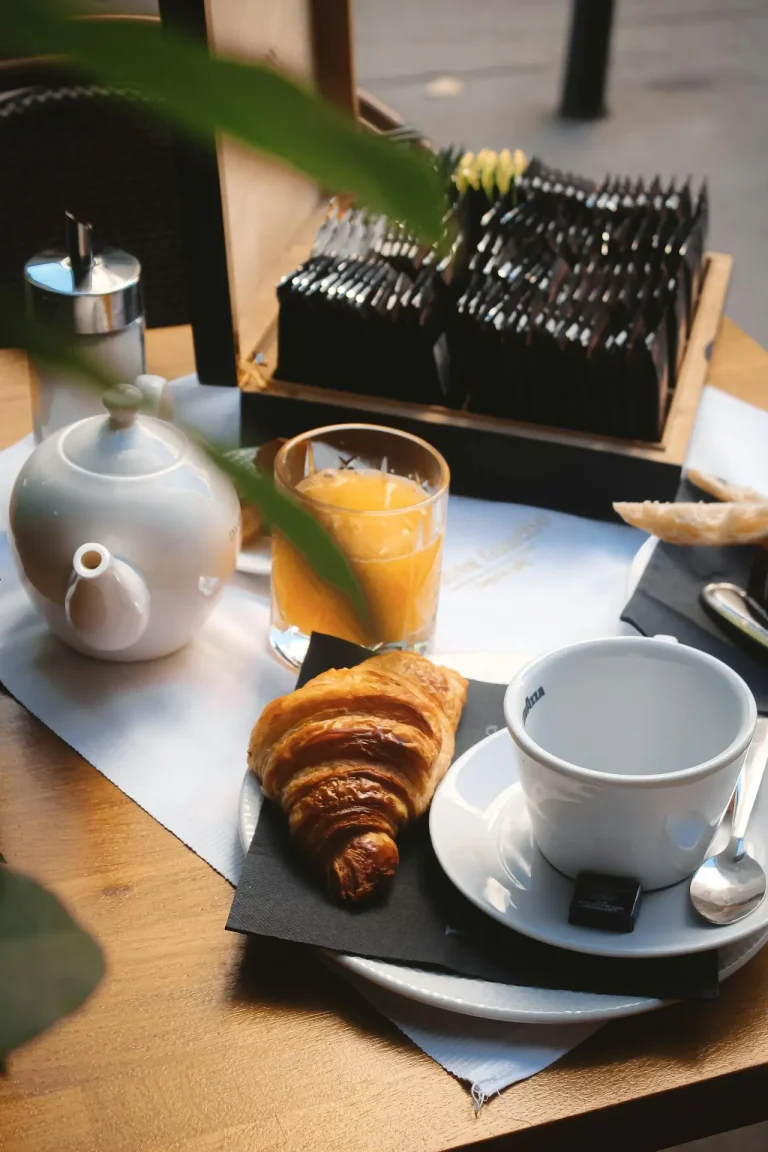 Breakfast croissant, orange juice, teapot and tea chest. French continental breakfast